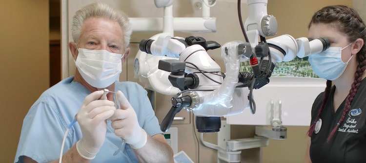 Un dentiste utilise un microscope opératoire pour un traitement endodontique avancé