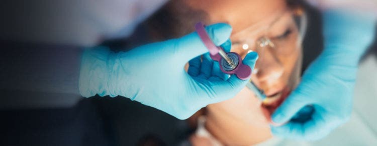 Un professionnel dentaire prépare une solution anesthésiante pour assurer le confort du patient lors d'interventions préventives.